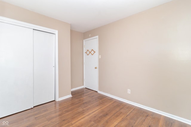 unfurnished bedroom with wood-type flooring and a closet