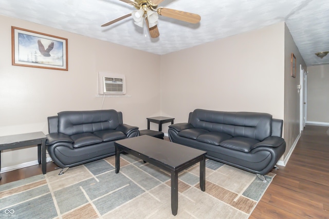 living room with hardwood / wood-style flooring, ceiling fan, and a wall mounted air conditioner