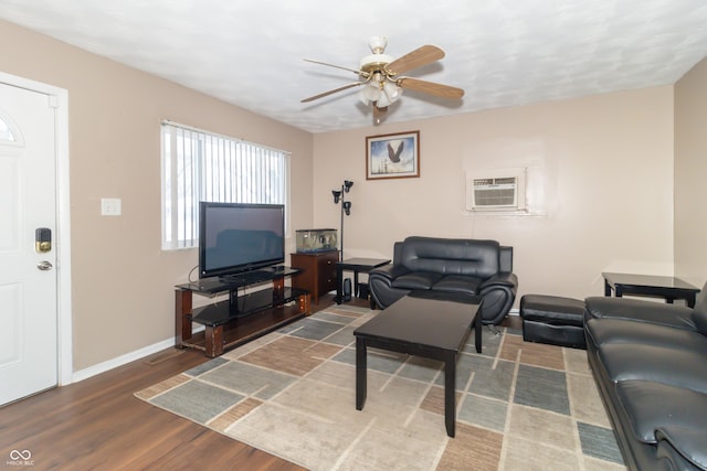 living room featuring a wall unit AC, dark wood-type flooring, and ceiling fan