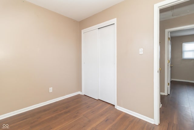 unfurnished bedroom featuring a closet and dark hardwood / wood-style flooring