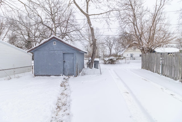 yard layered in snow with a storage unit