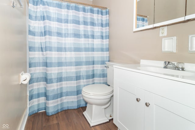 bathroom with toilet, vanity, and hardwood / wood-style flooring