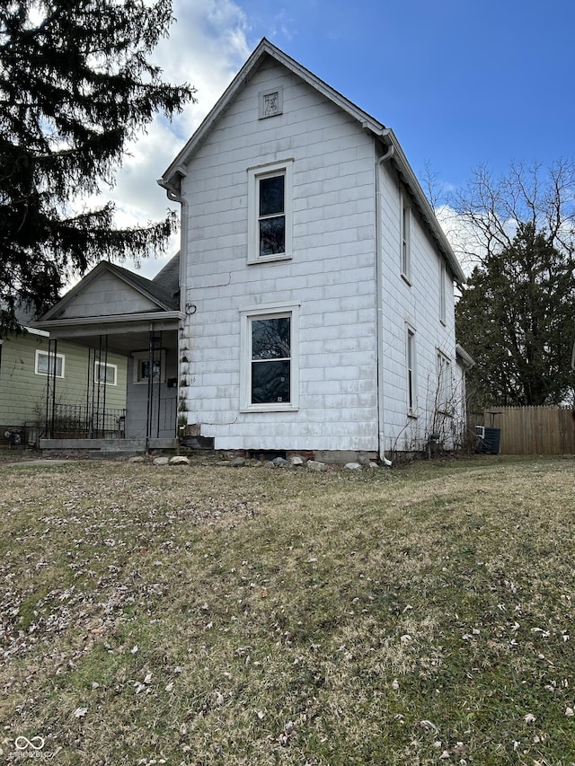 view of front of home with covered porch, cooling unit, and a front lawn