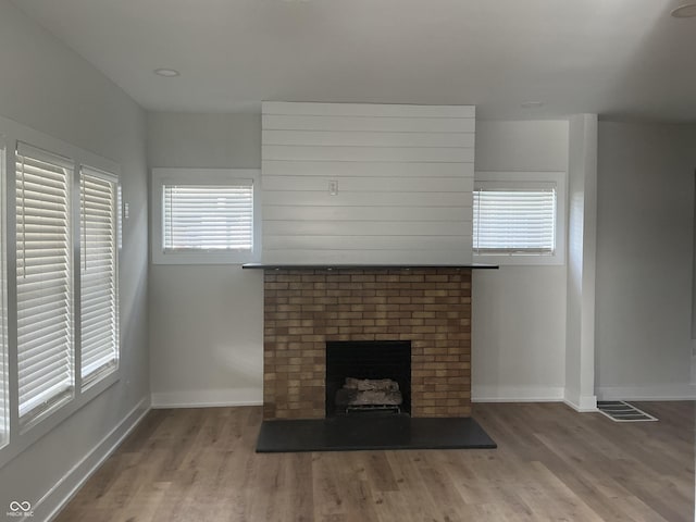 unfurnished living room featuring a fireplace and hardwood / wood-style floors