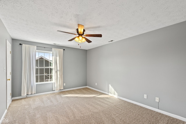 spare room with ceiling fan, light carpet, and a textured ceiling