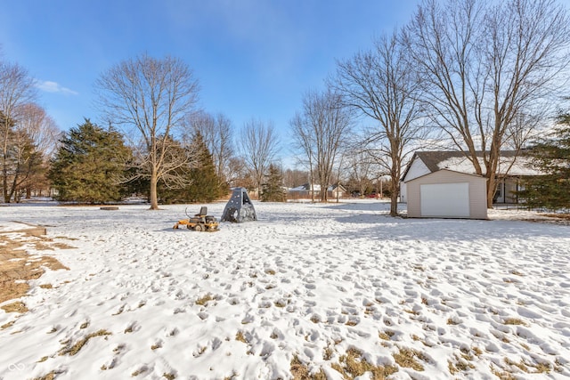 snowy yard featuring a garage