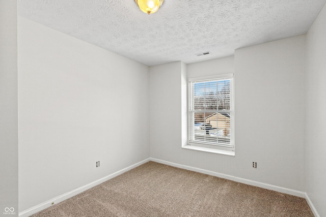 unfurnished room with carpet floors and a textured ceiling