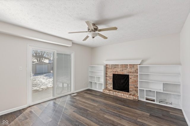 unfurnished living room featuring ceiling fan, a fireplace, dark hardwood / wood-style flooring, and a textured ceiling