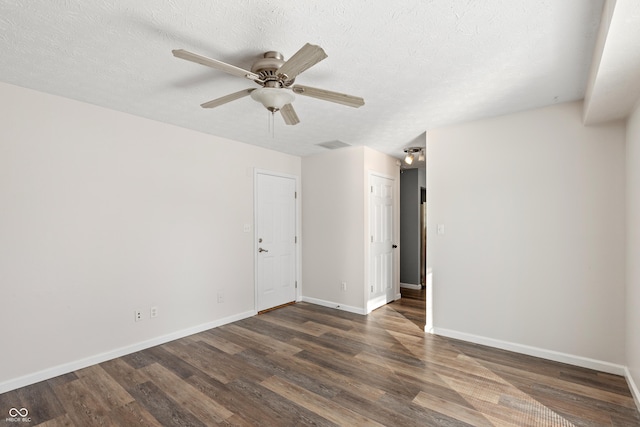 empty room with dark wood-type flooring, a textured ceiling, and ceiling fan