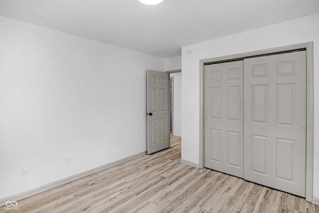 unfurnished bedroom featuring light hardwood / wood-style floors and a closet