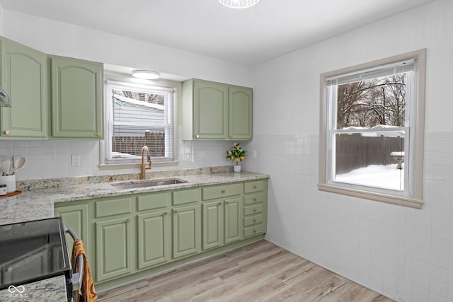 kitchen with a healthy amount of sunlight, light wood-type flooring, range, and sink