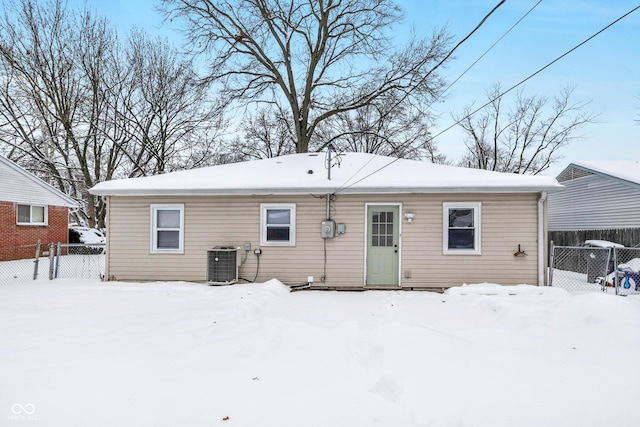 snow covered back of property featuring central AC