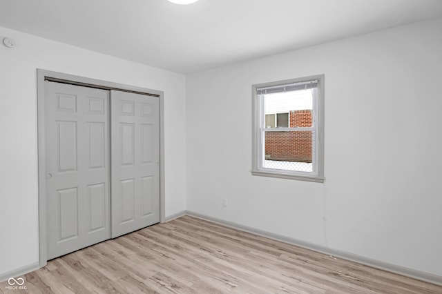 unfurnished bedroom featuring a closet and light wood-type flooring