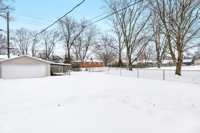 yard covered in snow with a garage and an outdoor structure