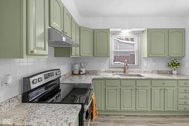 kitchen with light stone counters, electric stove, sink, and green cabinetry