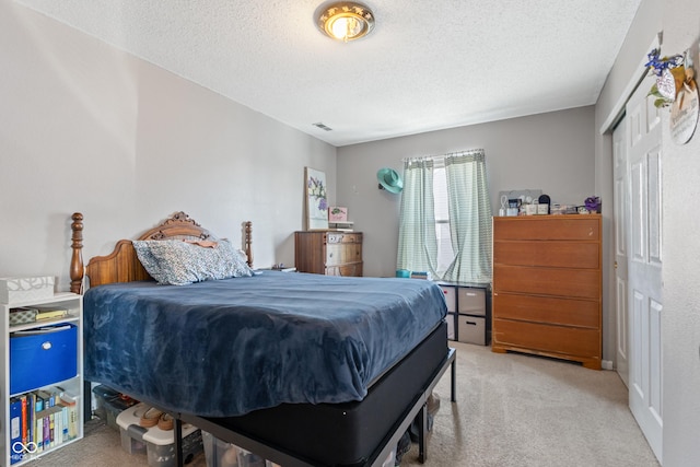 bedroom featuring a textured ceiling, a closet, and carpet flooring