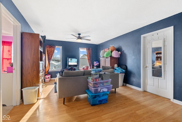 living room with light wood-type flooring and ceiling fan