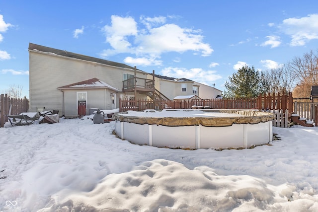 snow covered property featuring a covered pool