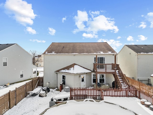 snow covered property with a deck