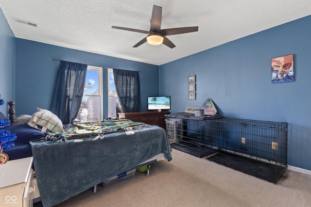 carpeted bedroom featuring a textured ceiling and ceiling fan