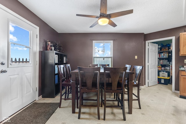 dining space with a textured ceiling and ceiling fan