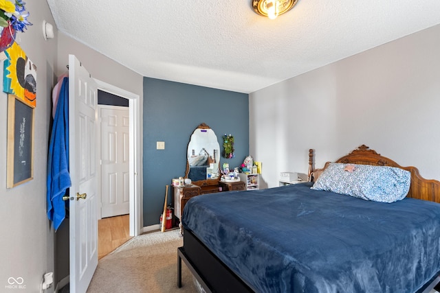 bedroom featuring a textured ceiling and light carpet