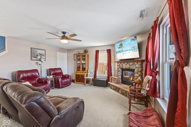 carpeted living room with a fireplace, a textured ceiling, and ceiling fan