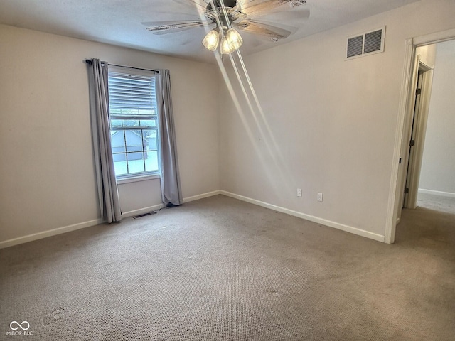 carpeted spare room featuring ceiling fan