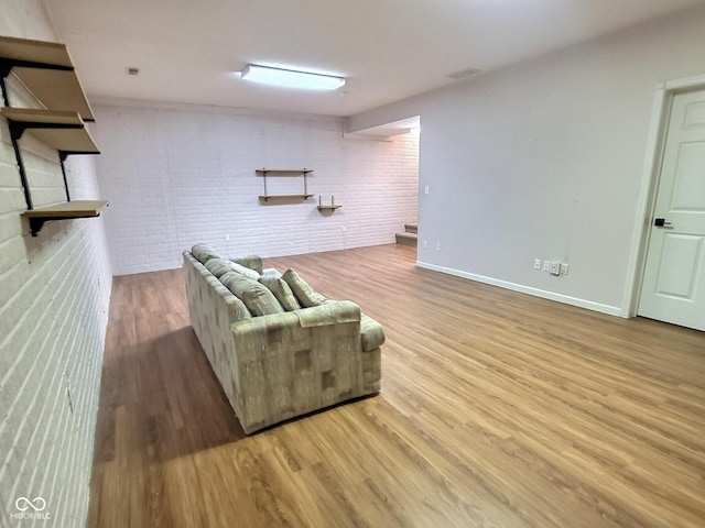 living room with light wood-type flooring and brick wall