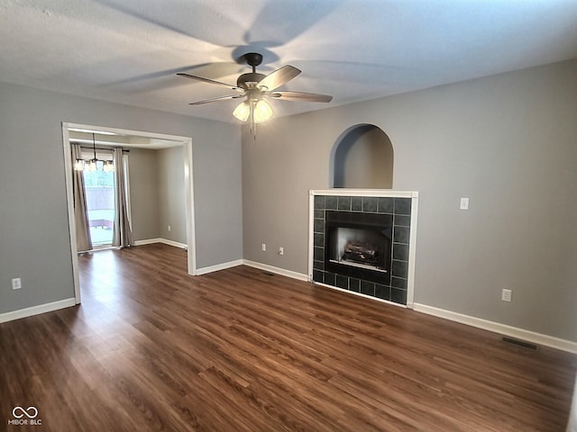 unfurnished living room with dark wood-type flooring, ceiling fan, and a fireplace