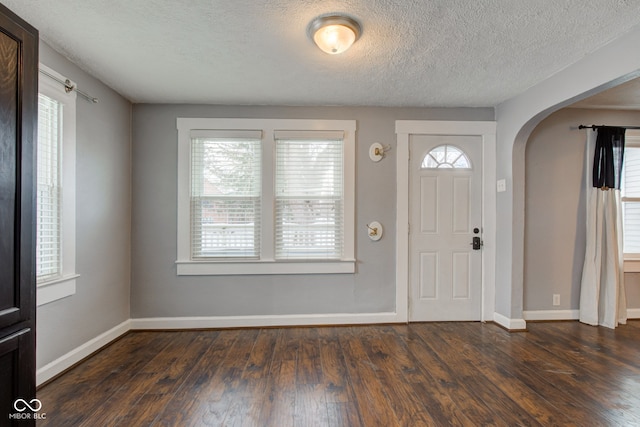 foyer with a textured ceiling and dark hardwood / wood-style flooring