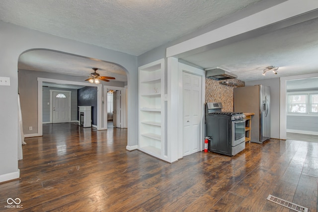 kitchen with appliances with stainless steel finishes, ceiling fan, dark hardwood / wood-style floors, a textured ceiling, and built in features