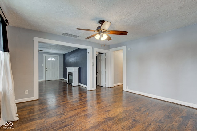 unfurnished living room with ceiling fan, a textured ceiling, and dark hardwood / wood-style floors