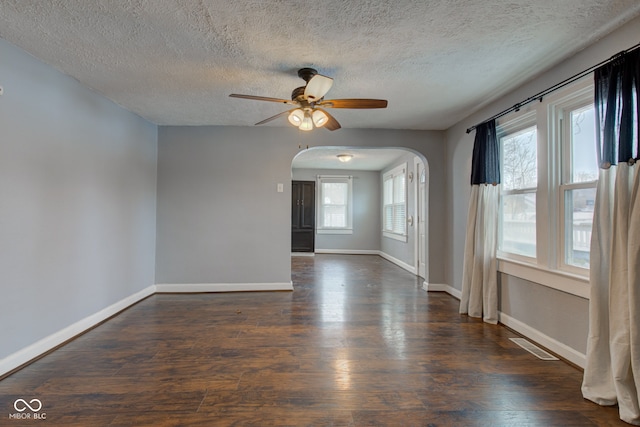 unfurnished room with ceiling fan, dark hardwood / wood-style flooring, and a textured ceiling