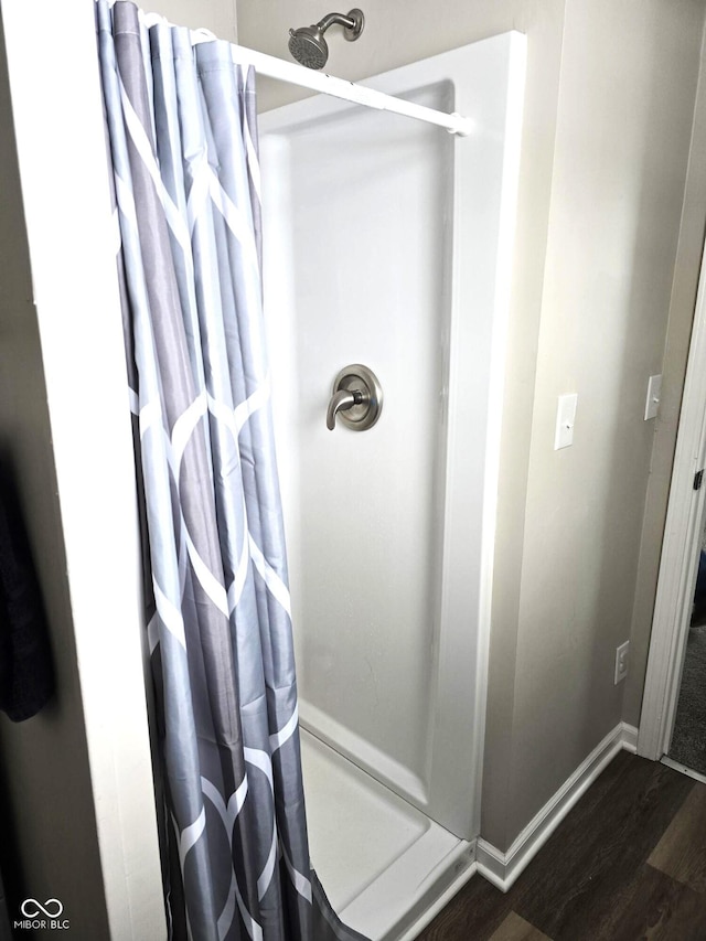 bathroom with hardwood / wood-style flooring and a shower with curtain