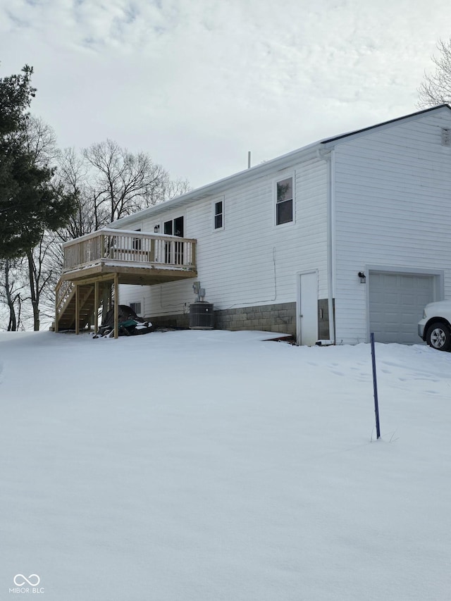 snow covered property featuring a deck and central AC