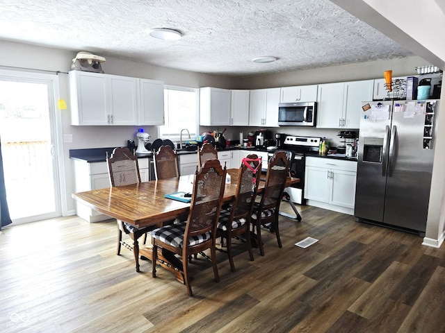 dining room with hardwood / wood-style flooring, a textured ceiling, and a wealth of natural light