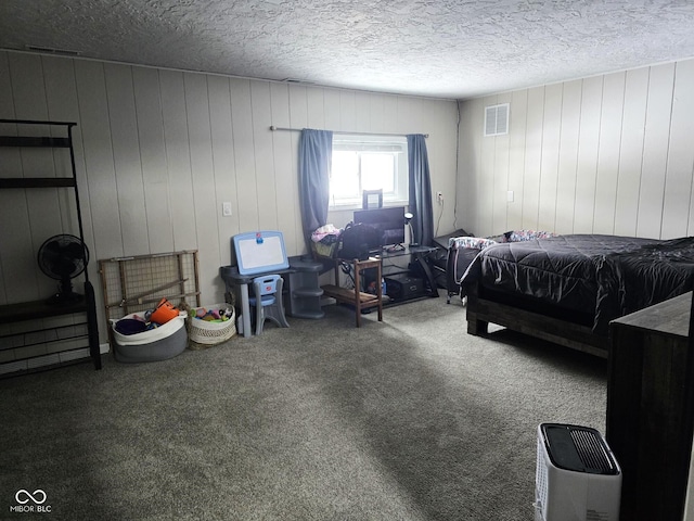 carpeted bedroom with wooden walls and a textured ceiling