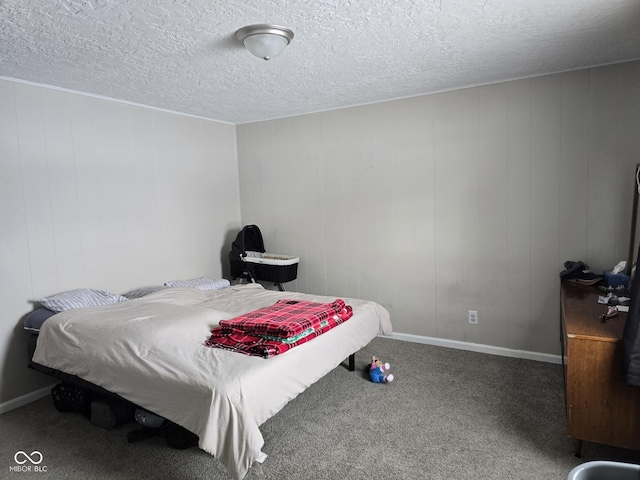 bedroom featuring wooden walls, carpet, and a textured ceiling