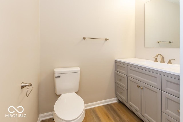 bathroom with hardwood / wood-style flooring, vanity, and toilet