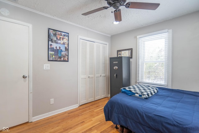 bedroom with ceiling fan, wood-type flooring, a textured ceiling, and a closet