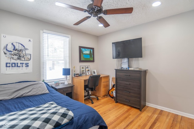 bedroom with a textured ceiling, light hardwood / wood-style floors, and ceiling fan