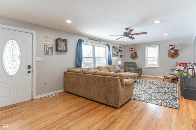 living room featuring a textured ceiling, hardwood / wood-style flooring, and ceiling fan