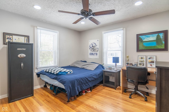 bedroom featuring a textured ceiling, light hardwood / wood-style floors, and ceiling fan