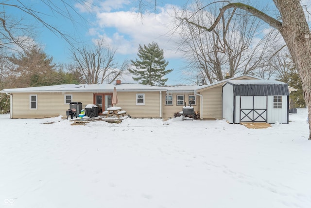 snow covered property with a shed