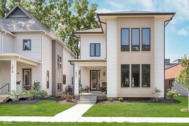 view of front of home featuring a porch, a front yard, and a shingled roof