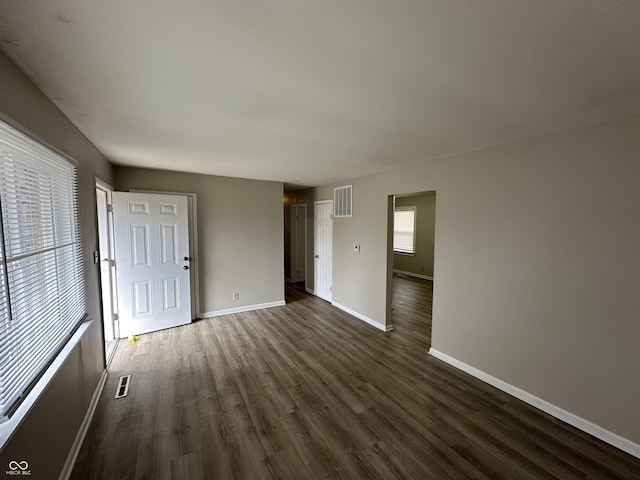 unfurnished living room with dark hardwood / wood-style flooring