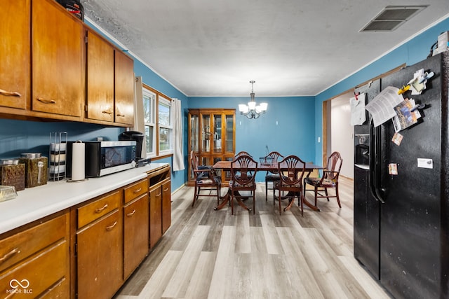 kitchen featuring a chandelier, decorative light fixtures, and light hardwood / wood-style floors