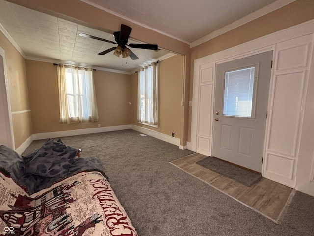 entryway featuring ceiling fan, crown molding, and carpet flooring