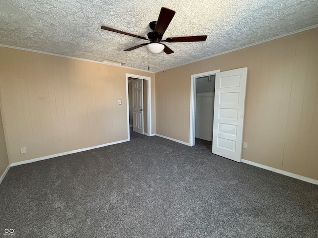 unfurnished bedroom featuring a closet, wood walls, ceiling fan, and dark colored carpet